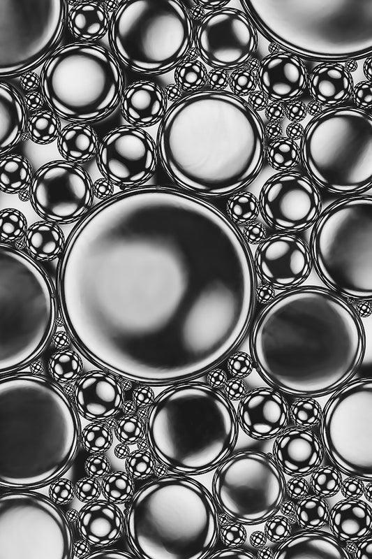 Chrome is a fine art acrylic photo print  of oil and water with a black and white background which creates an abstract wall art in which the predominant features are circular forms, playful compositions and a monochromatic palette.