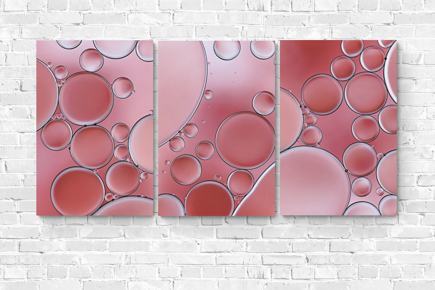 'Cozy Coral 2' is a contemporary acrylic wall art piece. It features an abstract, modern design with captivating coral colors and intricate textures created using oil and water. A visually engaging addition to any space. "Cozy Coral 2" is shown with "Cozy Coral 1 and 3" hanging on a white brick wall.