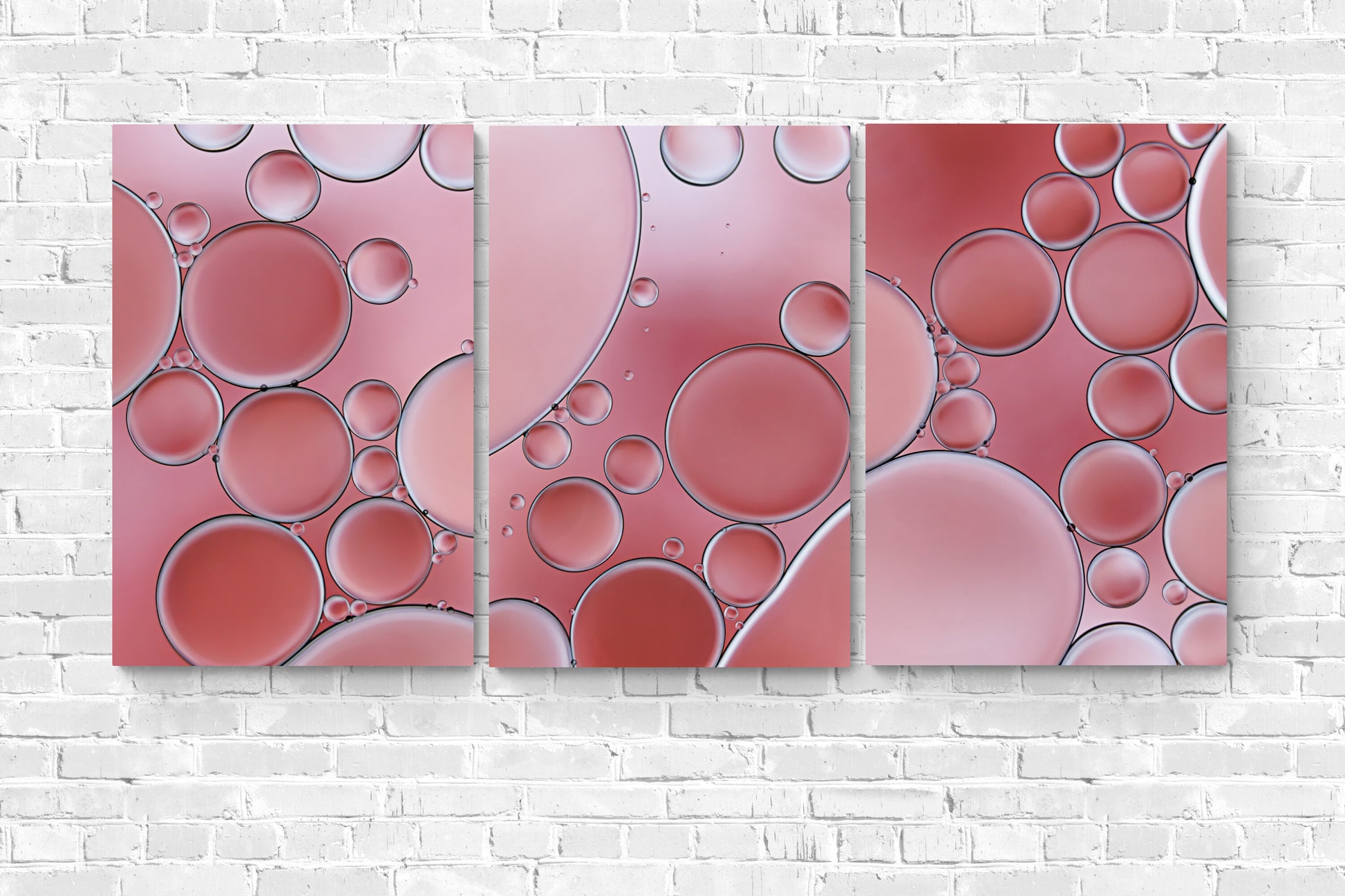 "Cozy Coral 3" is a contemporary acrylic wall art piece. It features an abstract, modern design with captivating coral colors and intricate textures created using oil and water. A visually engaging addition to any space. "Cozy Coral 3" is shown with "Cozy Coral 1 and 2" hanging on a white brick wall.